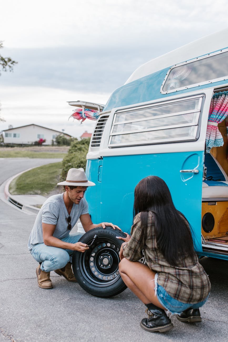 a couple changing the tire of the van