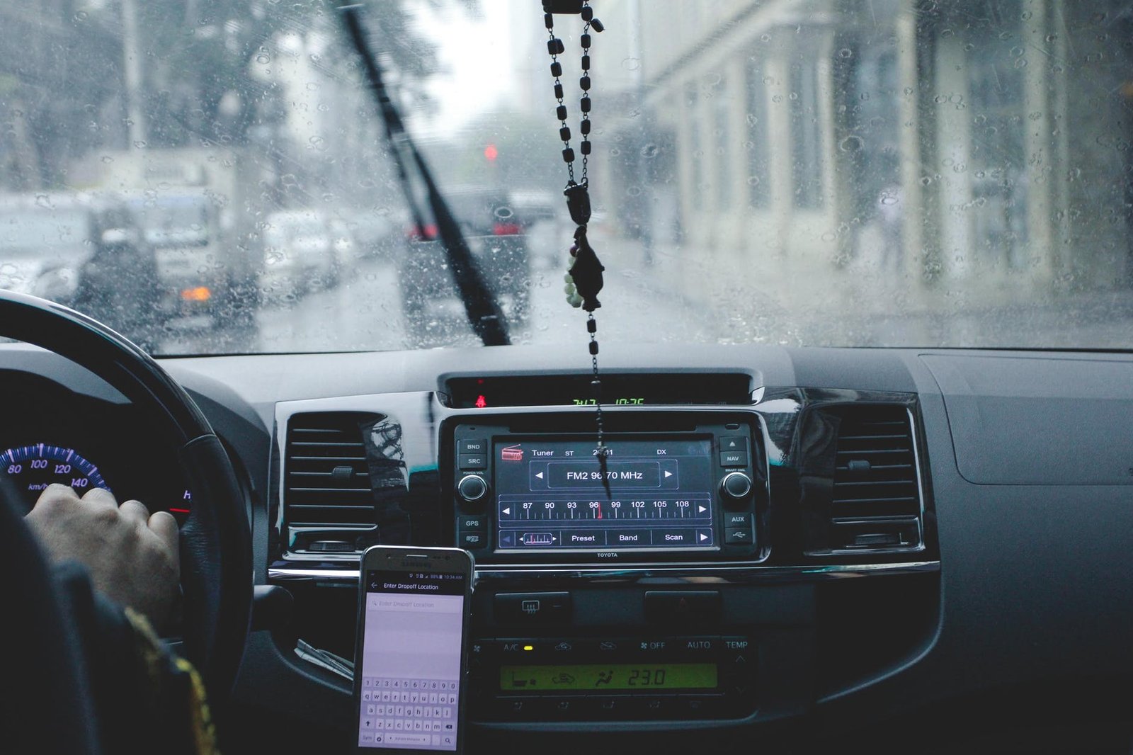 photo of person driving car while raining