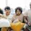 interested multiracial family watching tv on sofa together with dog
