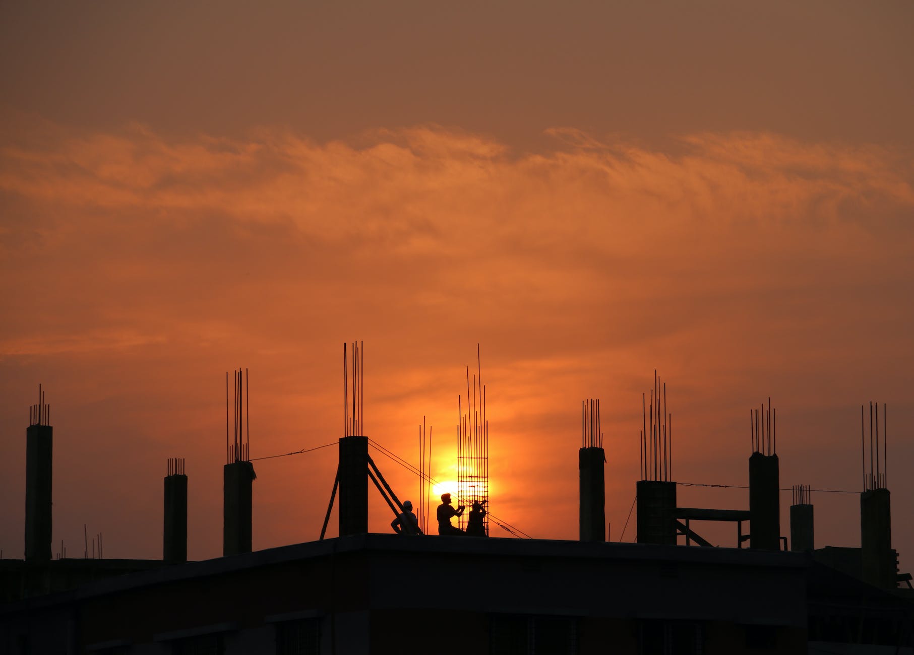 silhouette of men in construction site during sunset