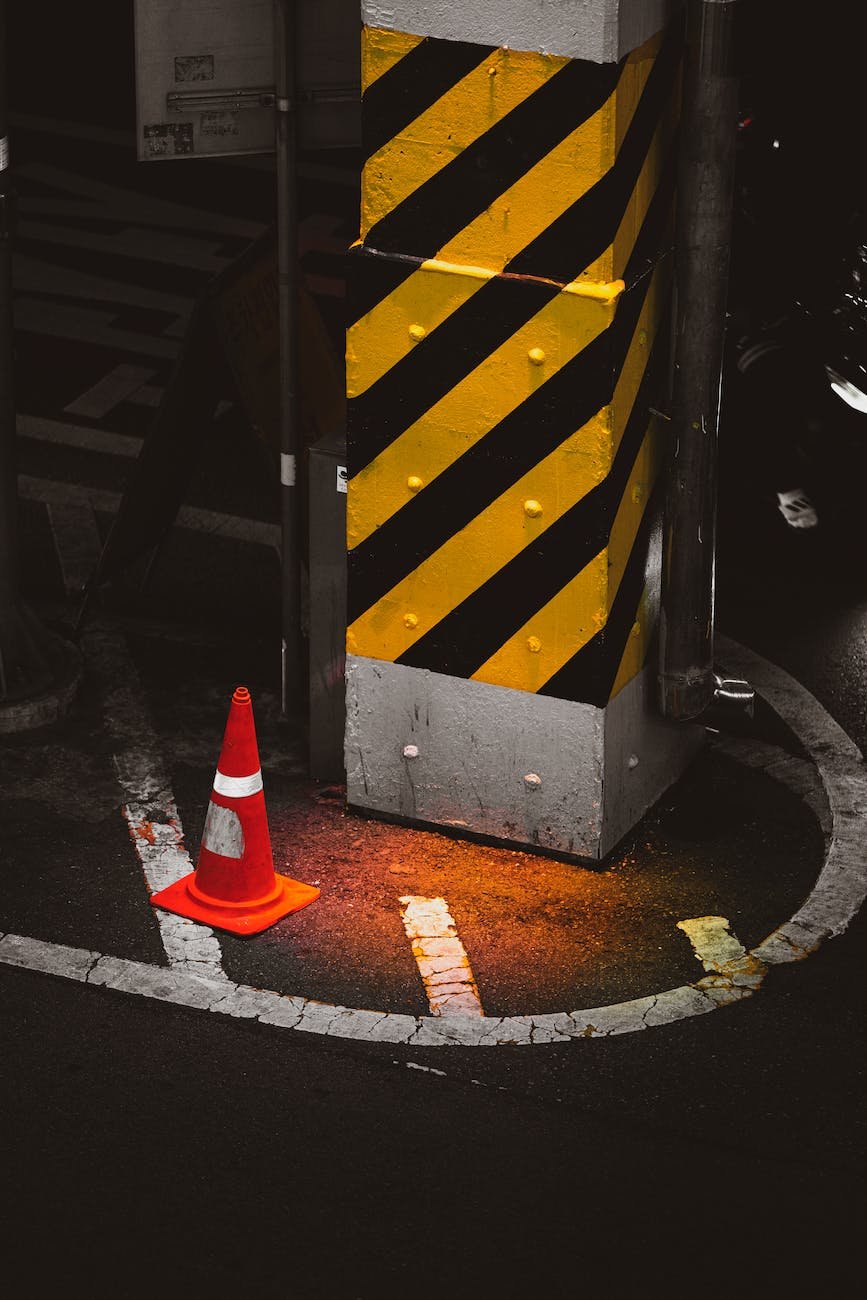 a traffic cone besides am iron post