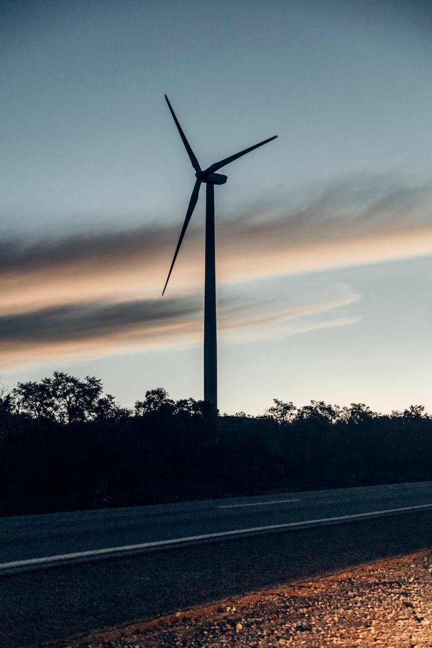 a wind turbine is silhouetted against the sky