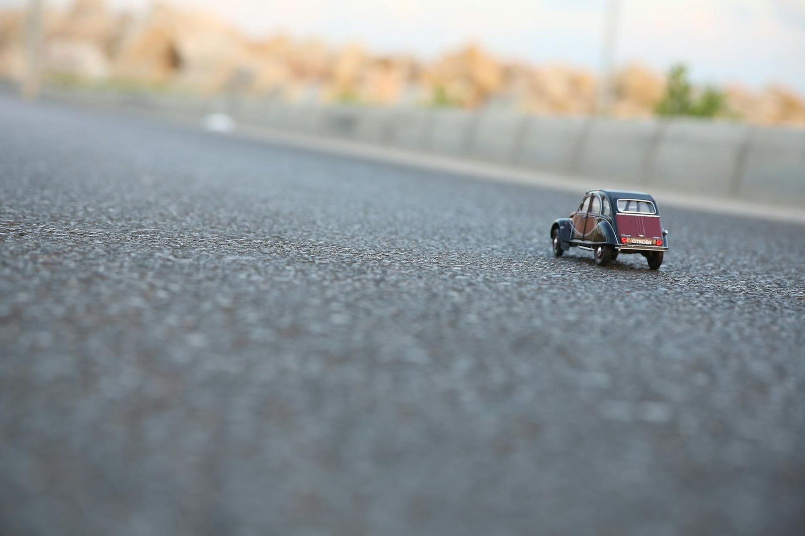 red and black car die cast model on ground